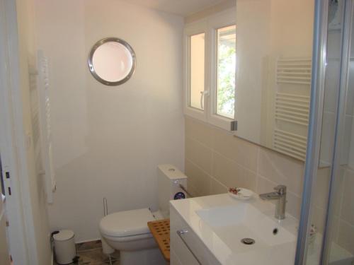 une salle de bain avec toilettes, lavabo et miroir dans l'établissement Maison dans falaise face à l'estuaire de la Gironde, à Gauriac