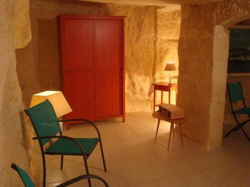 Cette chambre est dotée de chaises vertes et d'une porte rouge. dans l'établissement Maison dans falaise face à l'estuaire de la Gironde, à Gauriac