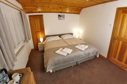 a bedroom with a bed with two towels on it at Willa 1910 in Karpacz