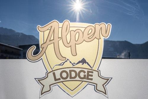 a sign that says alveragency lodge with a mountain at Alpenlodge Bad Mitterndorf in Bad Mitterndorf