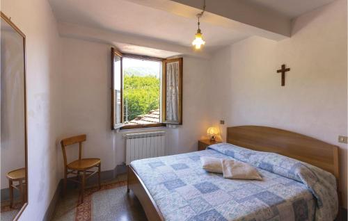 a bedroom with a bed and a cross on the wall at Stunning Apartment In Bagni Di Lucca Lu With 1 Bedrooms in Cocciglia