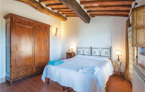 a bedroom with a bed and a wooden cabinet at Schivanoia 3 in Bagno Vignoni