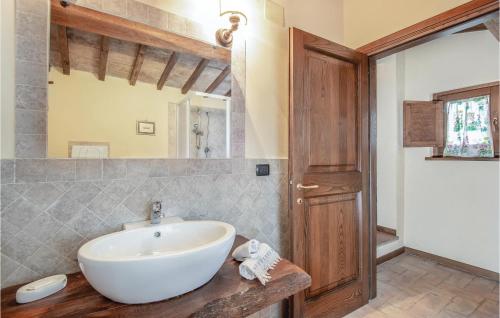 bagno con lavandino bianco e porta in legno di Casalino a Bazzano di Spoleto