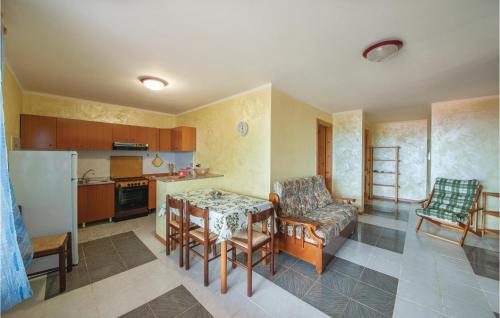 a kitchen with a table and chairs and a kitchen with a refrigerator at Awesome Apartment In Porto Alabe in Magomadas