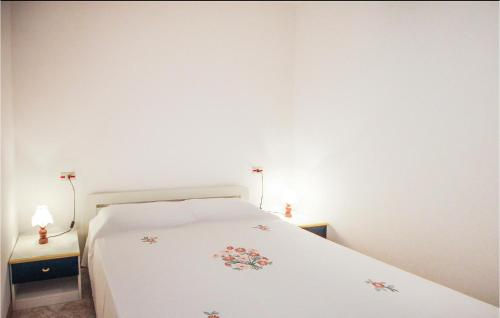 a bedroom with a white bed with flowers on it at Felix 3 in Lido di Scacchi