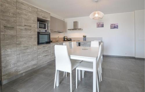 a kitchen with a white table and white chairs at 2 Bedroom Cozy Apartment In Algajola in Algajola