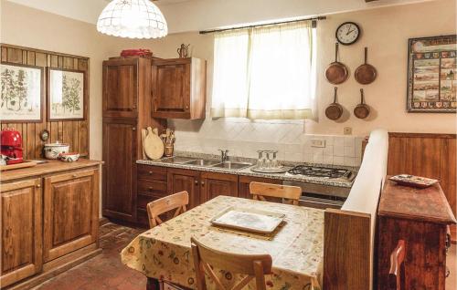 una cocina con armarios de madera y una mesa con sillas. en Pet Friendly Home In Partina Ar With Kitchenette, en Soci
