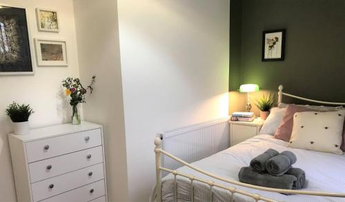 a bedroom with a white bed with a white dresser at Stylish modern 3-bed house nr Manchester city ctr in Whitefield