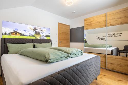 a bedroom with a bed with a poster of a cow at Alpenlodge Bad Mitterndorf in Bad Mitterndorf