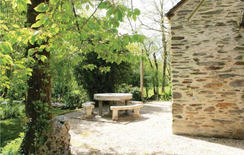 - une table de pique-nique dans un parc à côté d'un bâtiment en pierre dans l'établissement 2 Bedroom Nice Home In La Gacilly, à La Gacilly