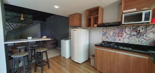 a kitchen with a white refrigerator and a counter at Ivy House Apart Hotel in Ciudad del Este