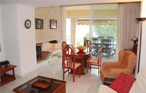 a living room with a table and chairs and a dining room at Nice Apartment In Port De Pollença in Port de Pollensa