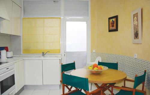 a kitchen with a table with a bowl of fruit on it at Nice Apartment In Port De Pollença in Port de Pollensa