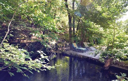 2 chaises assises sur un quai à côté d'une rivière dans l'établissement 2 Bedroom Awesome Home In Bedousse, à Malbosc