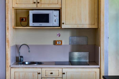 a kitchen with a sink and a microwave at Baba Residences in Alassio