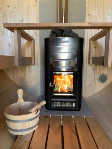 a fireplace in a room with a wooden floor at "ZeeLandZon" Holiday home by the lake with Jacuzzi and Sauna in Herkingen