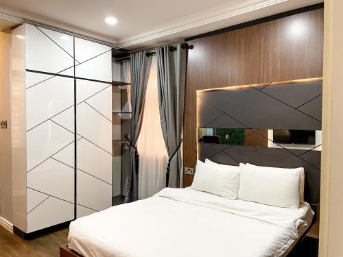 a bedroom with a white bed and a wooden wall at Whytescape Serviced Apartments in Abuja