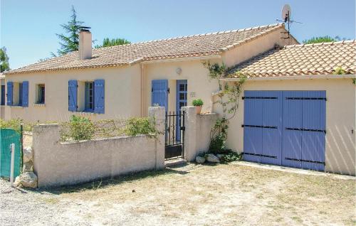 une maison avec des portes bleues et une clôture dans l'établissement Cozy Home In St Pons De Mauchiens, à Saint-Pons-de-Mauchiens