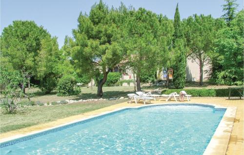 une piscine avec une table, des chaises et des arbres dans l'établissement Cozy Home In St Pons De Mauchiens, à Saint-Pons-de-Mauchiens
