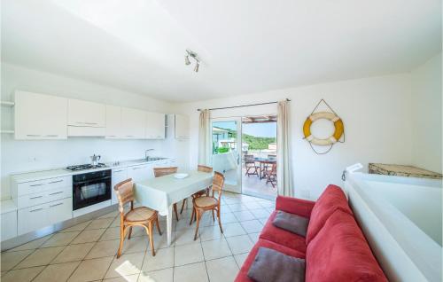 a kitchen and living room with a red couch and a table at Trilo 6 in Baja Sardinia