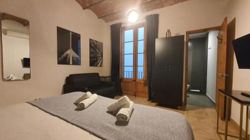 Barrio Gotico Apartments Escudellers في برشلونة: غرفة نوم عليها سرير وفوط