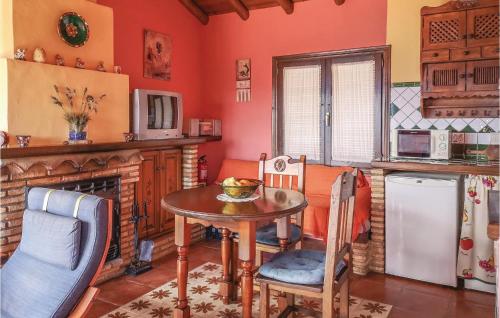 cocina con mesa, sillas y chimenea en One-Bedroom Holiday Home in Benalauria, en Benalauría