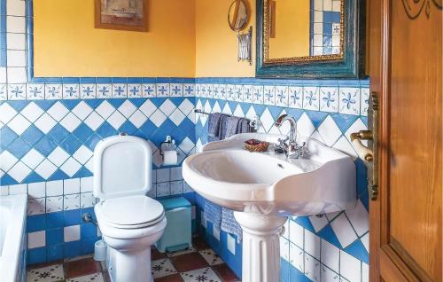a blue and white bathroom with a sink and a toilet at Cozy Home In Benalaura With House A Mountain View in Benalauría