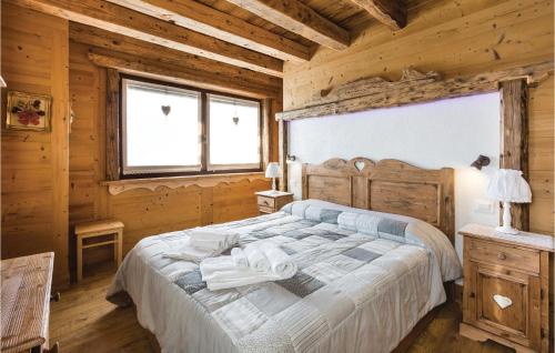 a bedroom with a bed in a log cabin at Pettirosso 1 in Comeglians