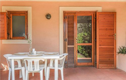 a white table with white chairs and a door to a patio at Trilo 6 in San Teodoro