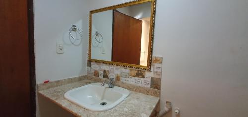 a bathroom with a sink and a mirror at Ivy House Apart Hotel in Ciudad del Este