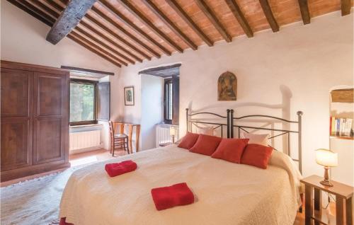 una camera da letto con un grande letto con cuscini rossi di Alabarda a Vasciano Nuovo