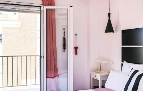 a bedroom with a bed and a sliding glass door at Amazing Apartment In Tossa De Mar With Kitchen in Tossa de Mar