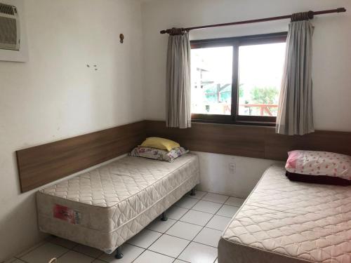 twee bedden in een kamer met een raam bij Horizonte da serra 1 in Gravatá