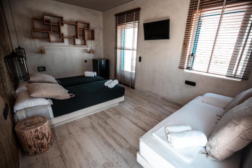 a bedroom with two beds and a couch in it at Ios Resort in Ios Chora