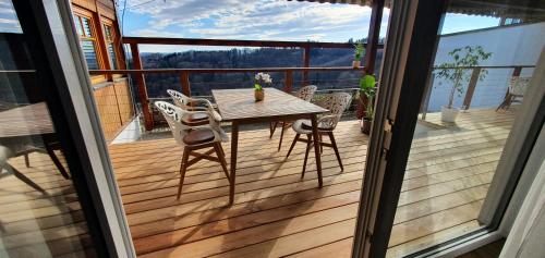 een houten terras met een tafel en stoelen op een balkon bij Weingut & Ferienwohnungen Lenhard in Lang