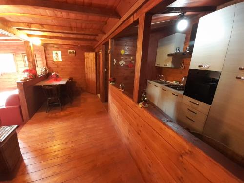 a kitchen with wooden floors and a table in a cabin at Parco Gessilandia in Sassofeltrio