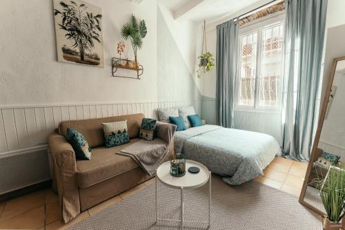 un salon avec un canapé et un lit dans l'établissement THE GAÏA, à Antibes