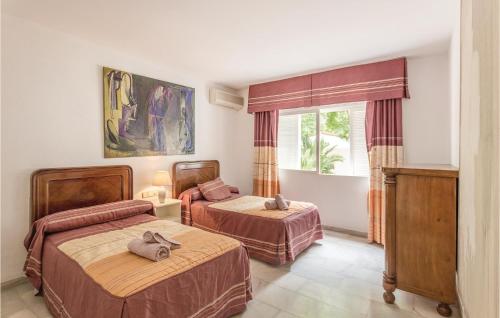 ラ・カラ・デ・ミハスにあるAmazing Home In Mijas Costa With 7 Bedrooms, Wifi And Private Swimming Poolのベッドルーム1室(ベッド2台、窓付)