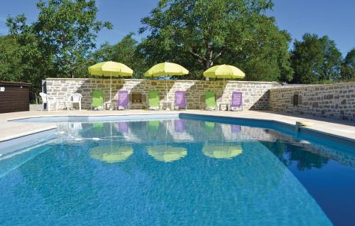 einen Pool mit Stühlen und Sonnenschirmen im Hof in der Unterkunft La Martine in Padirac