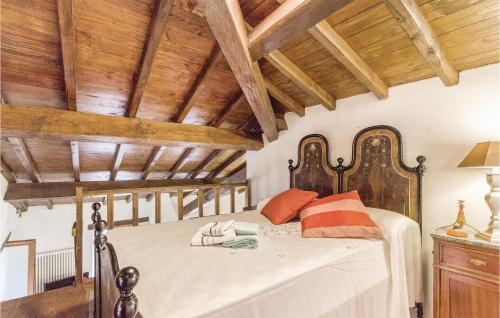 a bedroom with a large bed with wooden ceilings at Casa Matilde in Comano