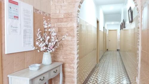a hallway with a vase of flowers on a table at CASA DA AVÓ - Casa típica em Olhão, perto da Marina in Olhão