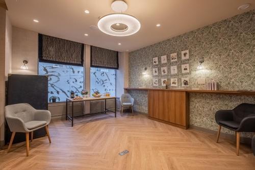 a waiting room with chairs and a desk and a window at Hotel Litteraire Le Swann, BW Premier Collection in Paris