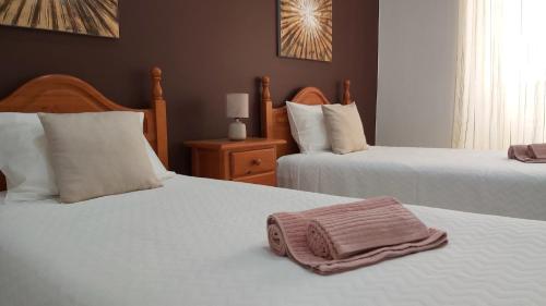 a bedroom with two beds with white sheets at CASA DA AVÓ - Casa típica em Olhão, perto da Marina in Olhão