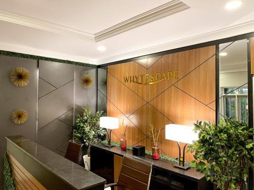 a lobby with a wall with a sign on it at Whytescape Serviced Apartments in Abuja