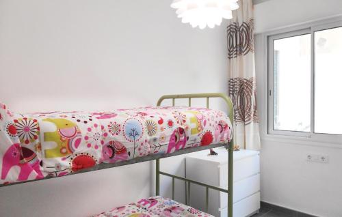 トッサ・デ・マールにあるAmazing Apartment In Tossa De Mar With 2 Bedroomsのベッドルーム1室(花柄のベッドカバー付)