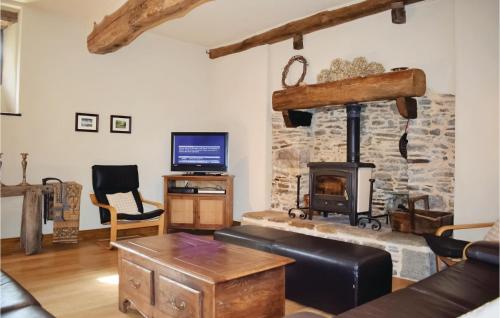 un salon avec une cheminée en pierre et une télévision dans l'établissement Beautiful Home In Sougeal With Kitchen, à Sougéal