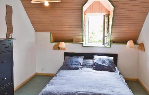 a bedroom with a bed with two pillows and a window at Awesome Home In Ploneour Lanvern With 3 Bedrooms And Wifi in Plonéour-Lanvern