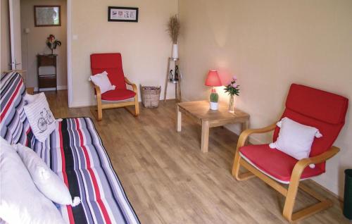 Una sala de estar con dos sillas rojas y una mesa. en 2 Bedroom Cozy Home In Saint - Agne, en Saint-Aigne