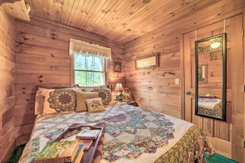 a bedroom with a bed in a room with wooden walls at Franklin Cabin with Porch Near Hiking and Waterfalls! in Franklin