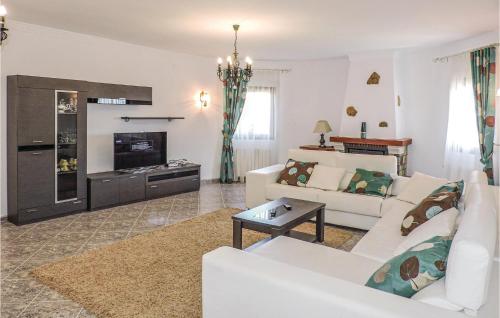 a living room with two white couches and a tv at 5 Bedroom Amazing Home In Miami Platja in Miami Platja